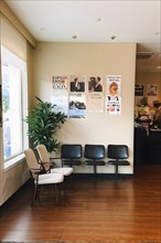 Minimalist styled waiting room with an ordered row of chairs lined up, AI generated