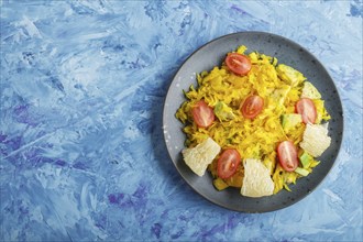 Fried pomelo with tomatoes and avocado on blue concrete background. Top view, copy space, myanmar