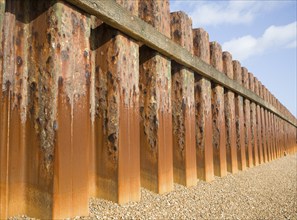 Rusty steel piling sea wall defences and shingle beach near Bawdsey Quay, Suffolk, England, United