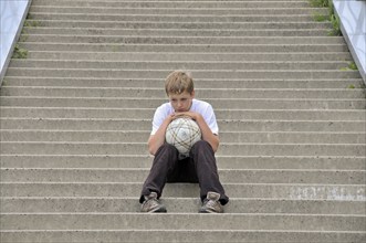 Lonely ten-year-old boy with his football, stairs to the viewing platform of the Chocolate Museum,