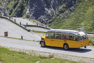 Historic postbus travelling along the Tremola, the world-famous serpentine road through the Val