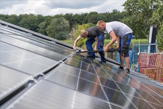 Installation of solar modules on the roof of a barn on a farm, over 210 photovoltaic modules are