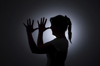 Symbol photo on the subject of being tricked. A young woman holds her hands in front of her face.