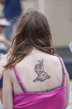 She Devil tattoo on back of young fair skinned woman