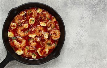 Greek saganaki, in an iron pan, saganaki with shrimp, shrimp in tomato sauce, with pepper and feta