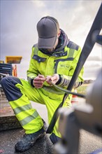 A worker in safety clothing doing manual work on a machine, glass fibre construction, Nagold, Black