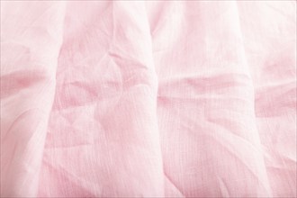 Fragment of pink linen tissue. Side view, natural textile background and texture. wave concept,