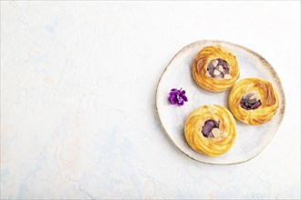 Small cheesecakes with jam and almonds with cup of coffee on a white concrete background. top view,