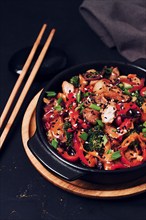 Asian cuisine, teriyaki meat with vegetables, in a cast-iron frying pan, close-up, no people