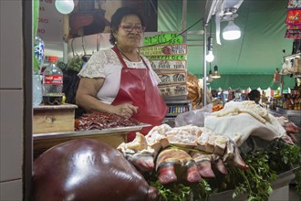 Oaxaca, Mexico, A vendor sells liver, bull's feet, and other meats at the Benito Juarez Market.