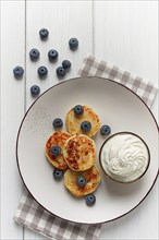 Cottage cheese pancakes, with blueberries, breakfast, on a white wooden table, no people, top view