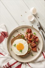 Breakfast, fried egg with bacon, micro-green, on a light background, no people, selective focus