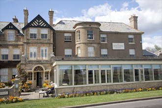 People sitting outside the Wentworth hotel in Aldeburgh, Suffolk, England on a sunny day in Spring