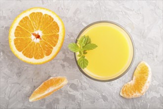 Glass of orange juice on a gray concrete background. Morninig, spring, healthy drink concept. Top