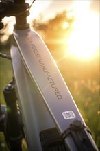 Bicycle frame with inscription at sunset in a meadow, e-bike, Black Forest, Gechingen, Germany,