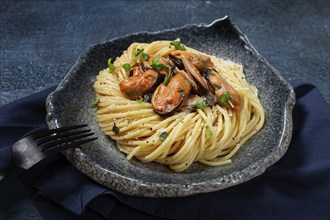 Spaghetti with mussels, without shell, pasta with peeled mussels, in carbonara sauce, micro-greens,