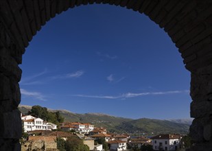 Residential buildings with terracotta ceramic tiled rooftops and mountain range viewed through a