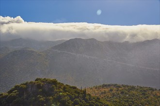 A majestic cloud bank over green overgrown mountains, Mani peninsula, Peloponnese, Greece, Europe