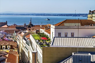 A scenic cityscape with ocean view, clear sky, and distant hills, Lisbon