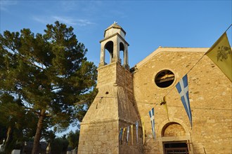 Church bell tower with neighbouring flags and blue sky, Koroni, Byzantine fortress, nunnery,