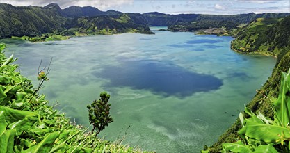 Calming view of the blue lake Lagoa Azul with the green hilly landscape under a clear sky, Lagoa