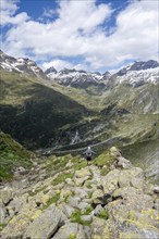 Mountaineer on hiking trail in front of picturesque mountain landscape, rocky mountain peaks with