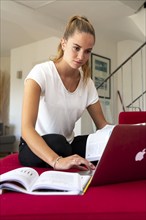 Young student learns at home, online, on her notebook