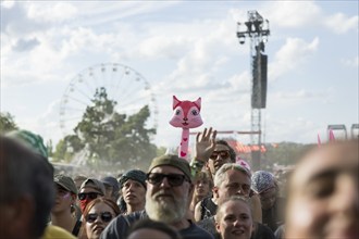 An inflatable cat looks out between festival visitors at the Highfield Festival on Saturday,