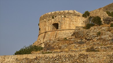 Old round stone tower on rocky ground with clear sky, Venetian Sea Fortress, Leper Island,