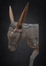 Head of the donkey, on a dark background, detail of the palm donkey, wooden figure from around