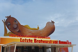 Large sausage with flames on a food truck with humorous lettering, snack bar Last sausage in front