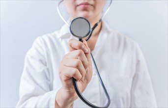 Female doctor hand showing stethoscope isolated. Female doctor holding stethoscope on white