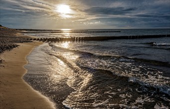 Sunset on the Baltic Sea beach, Ahrenshoop beach in the evening light with clouds, evening mood,