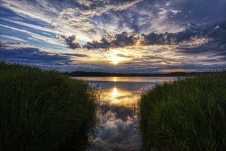 Dramatic sunset over a calm lake with cloud reflections, Rügen