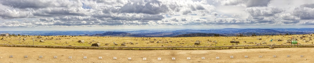 Wide landscape with fields and mountains under a dramatic cloudy sky, Harz Mountains, Brocken,