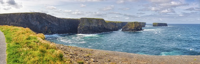 Cliff landscape with blue sea and cloudy sky, calm atmosphere along the coast, Kilkee