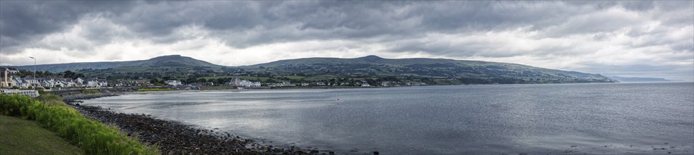 Coastal panorama with mountains in the background and cloudy sky, Ballycastle