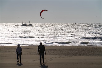 Kitesurfers and shrimp boats off the coast of Scheveningen, walkers on the beach, The Hague,