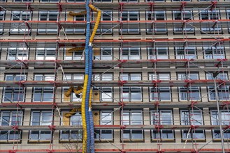 Large construction site, scaffolded shell of an office building complex, air hoses for building