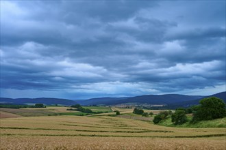 Wide landscape with fields and hills under a cloudy sky, summer, Mönchberg, Miltenberg, Spessart,