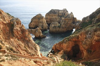 Praia do Pinhao, Lagos, Algarve, Portugal, Steep, rocky coast with clear water, rock formations and