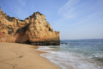 Praia do Pinhao, Lagos, Algarve, Portugal, beach with cliffs and rocky shores, gentle waves, blue