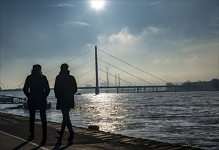 Dense fog is slowly lifting, riverside promenade on the Rhine near Düsseldorf, in front the