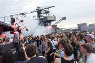 Celebrating visitors in front of excavators at the Melt Festival in Ferropolis on 12 July 2024.