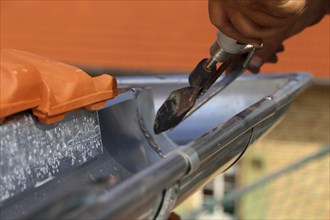 Roofer doing tinsmith work on a gutter