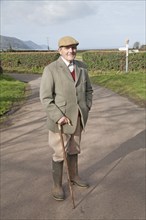 Smartly dressed gentleman out for his morning walk in Bossington, Exmoor national park, Somerset,