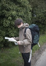 Model released young man hiker map reading