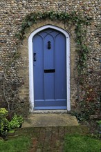 Blue door in flint home, Suffolk, England, UK