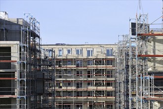 Photo of a large construction site in a newly developed residential area. Several apartment