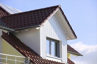 Large dormer window with wooden panelling on a tiled roof